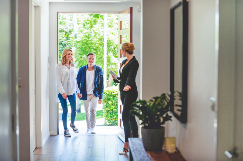 Real estate agent showing a young couple a new house